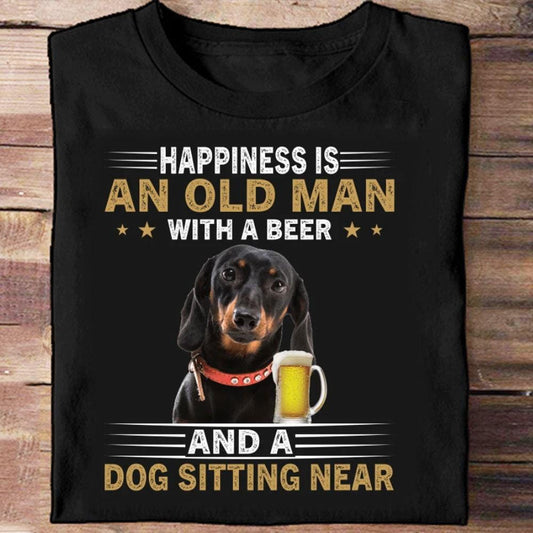 La felicidad es un anciano con una cerveza y un perro salchicha sentado cerca de las camisas